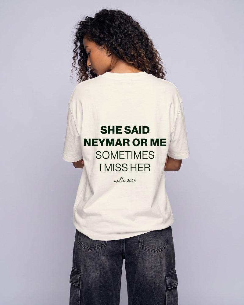 Camiseta oversized feminina MALTA® neymar or me off-white vista de costas no estúdio, com a frase “she said neymar or me, sometimes i miss her”