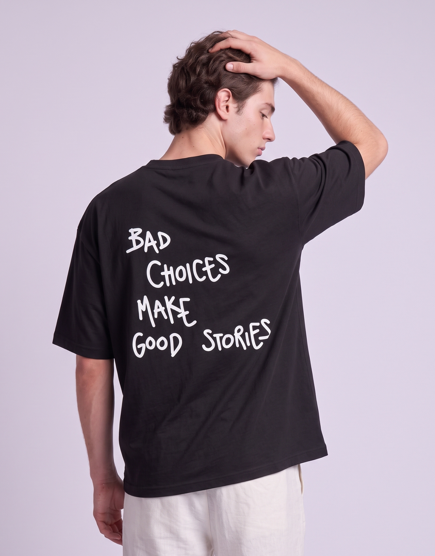 Camiseta oversized MALTA® Bad Choices preta, costas com a frase “bad choices make good stories”