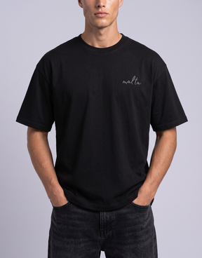 Camiseta oversized MALTA® Conditioned for Chaos preta vestida, vista de frente