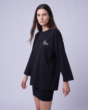 Camiseta oversized feminina MALTA® after party preta vestida de frente, no estúdio