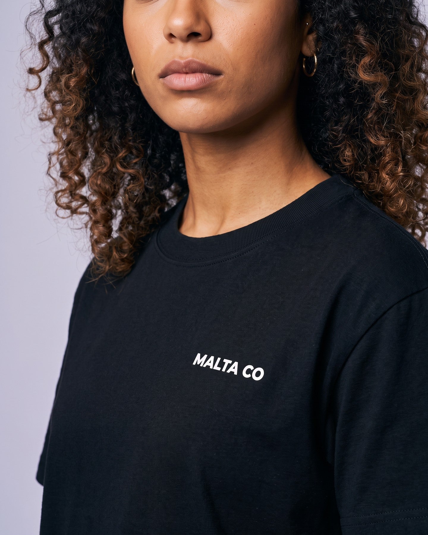 Detalhe da camiseta oversized MALTA® bad choices preta no corpo feminino