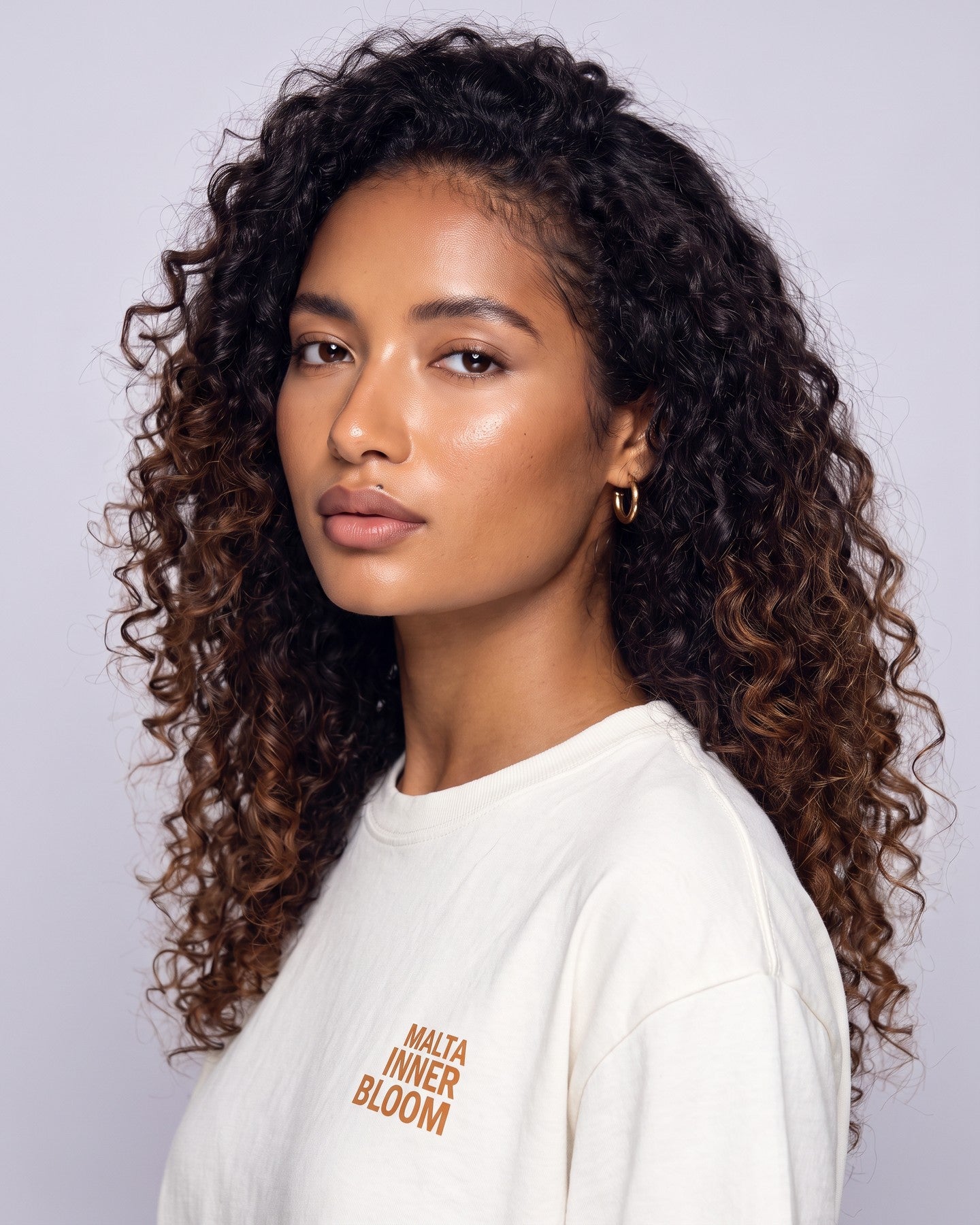 Detalhe da camiseta oversized MALTA® innerbloom off-white no corpo feminino