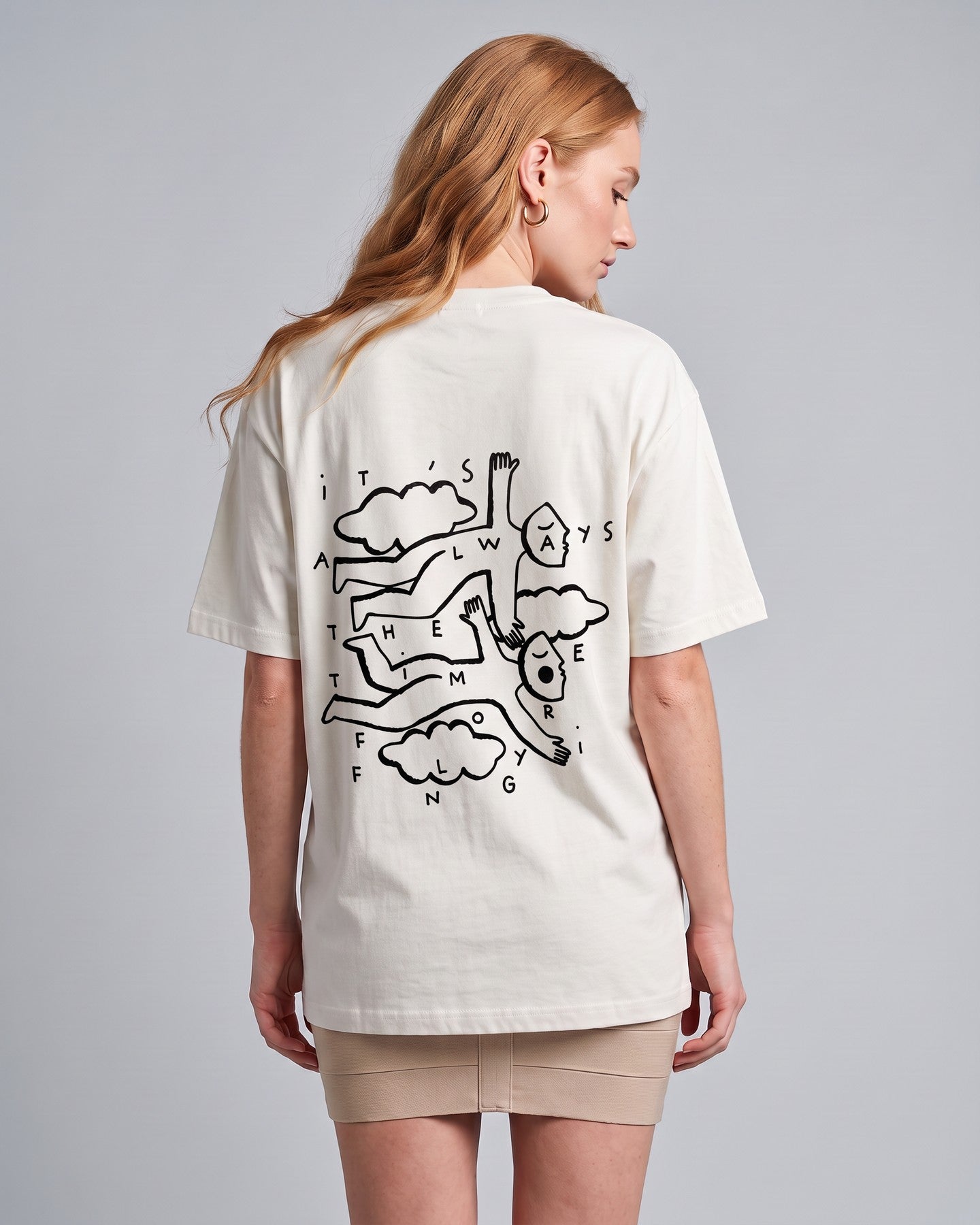 Camiseta oversized feminina MALTA® flying off-white vista de costas no estúdio, com a frase “it's always the time for flying”
