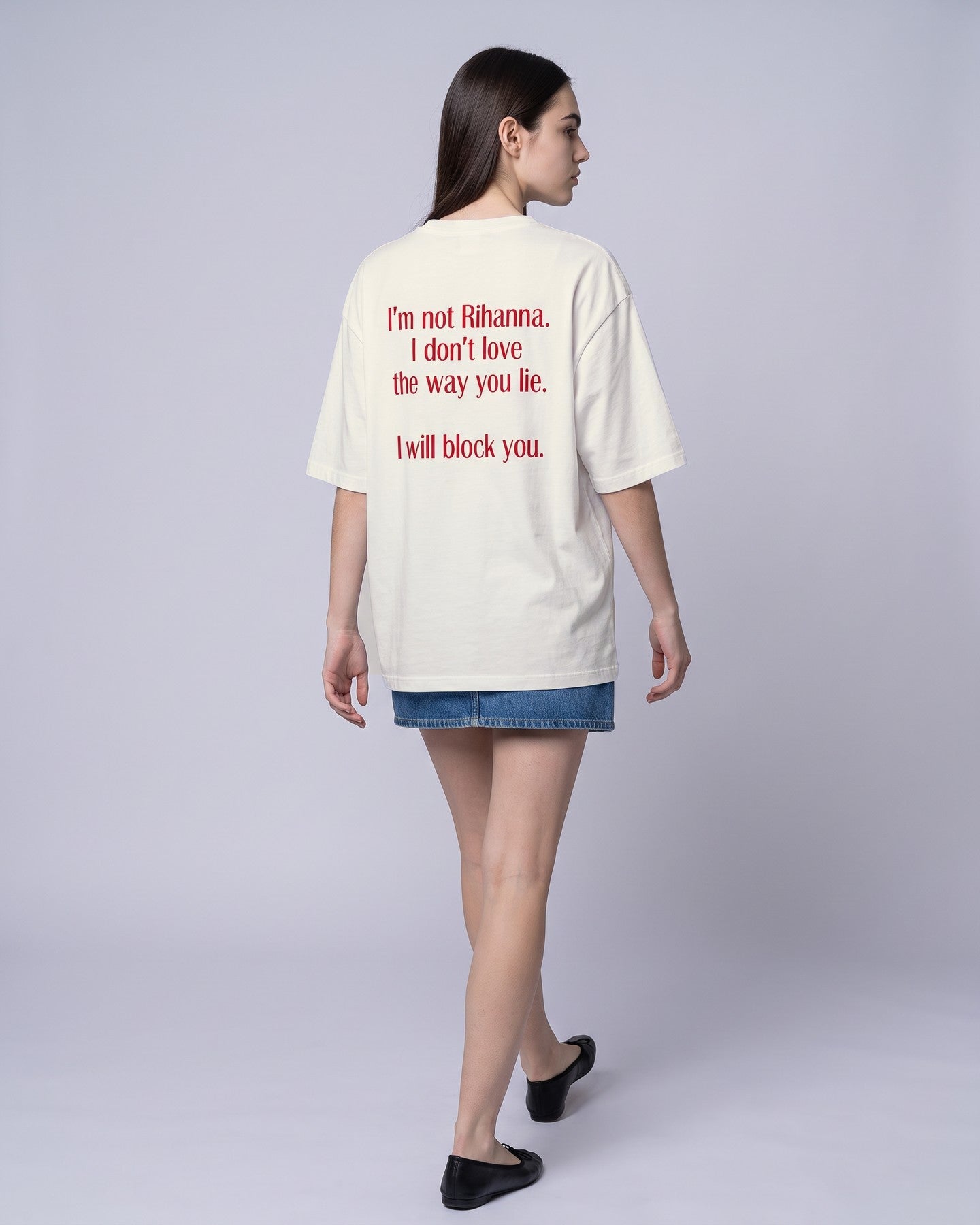 Camiseta oversized feminina MALTA® i will block you off-white vista de costas no estúdio, com a frase “i'm not rihanna, i don't love the way you lie, i will block you”