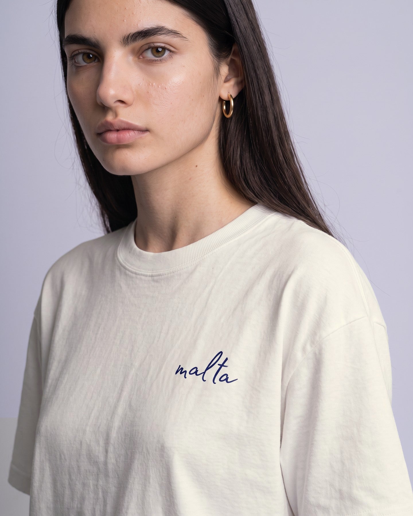 Detalhe da camiseta oversized MALTA® kiss brazilian off-white no corpo feminino