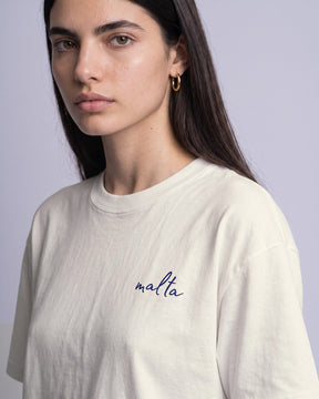 Detalhe da camiseta oversized MALTA® kiss brazilian off-white no corpo feminino