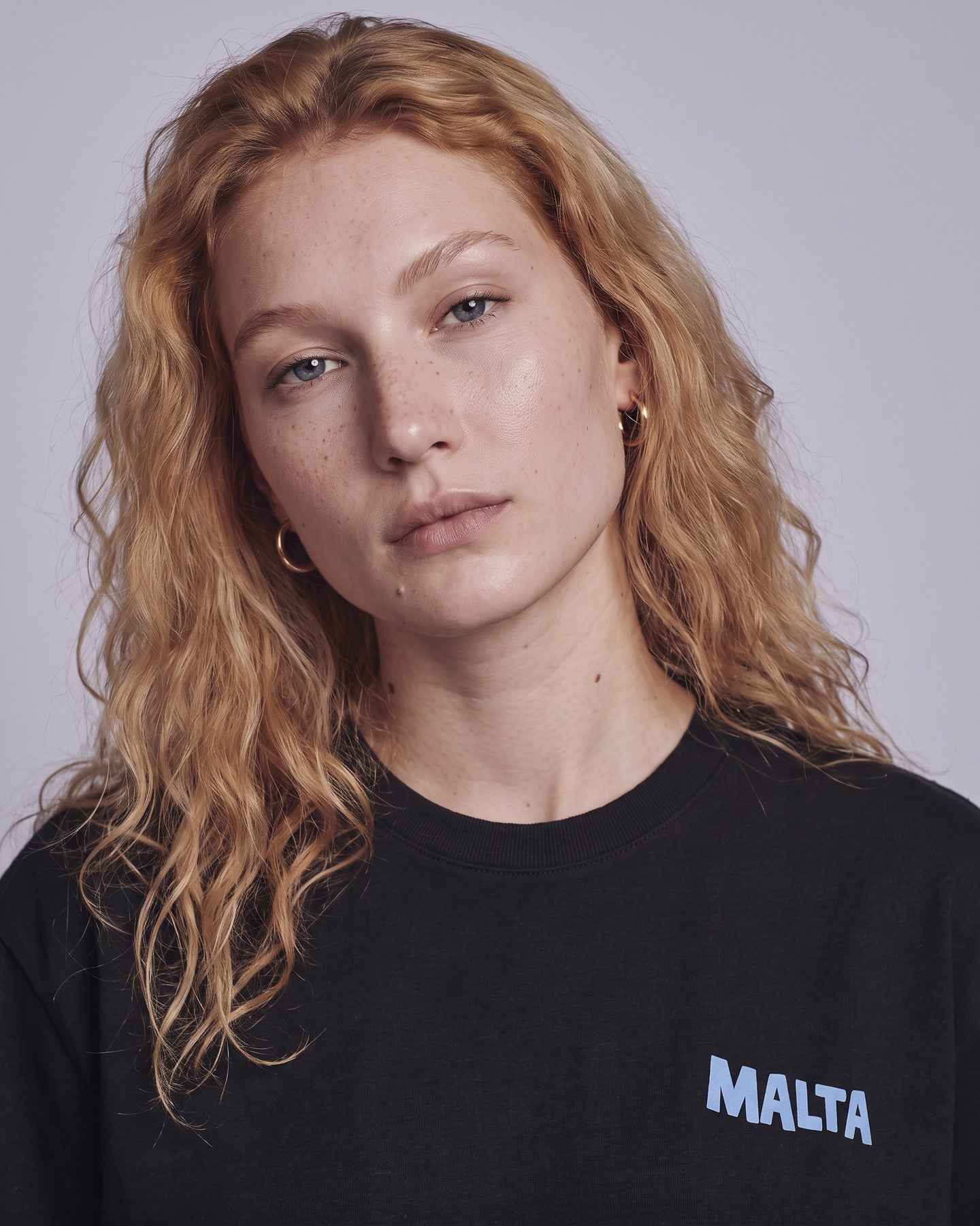 Detalhe da camiseta oversized MALTA® life goes on preta no corpo feminino