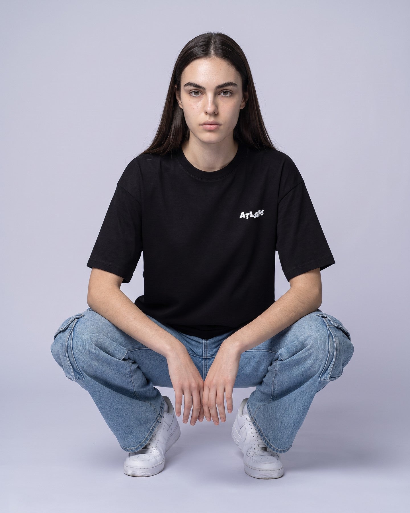 Camiseta oversized feminina MALTA® life is a simulation preta vestida de frente, no estúdio