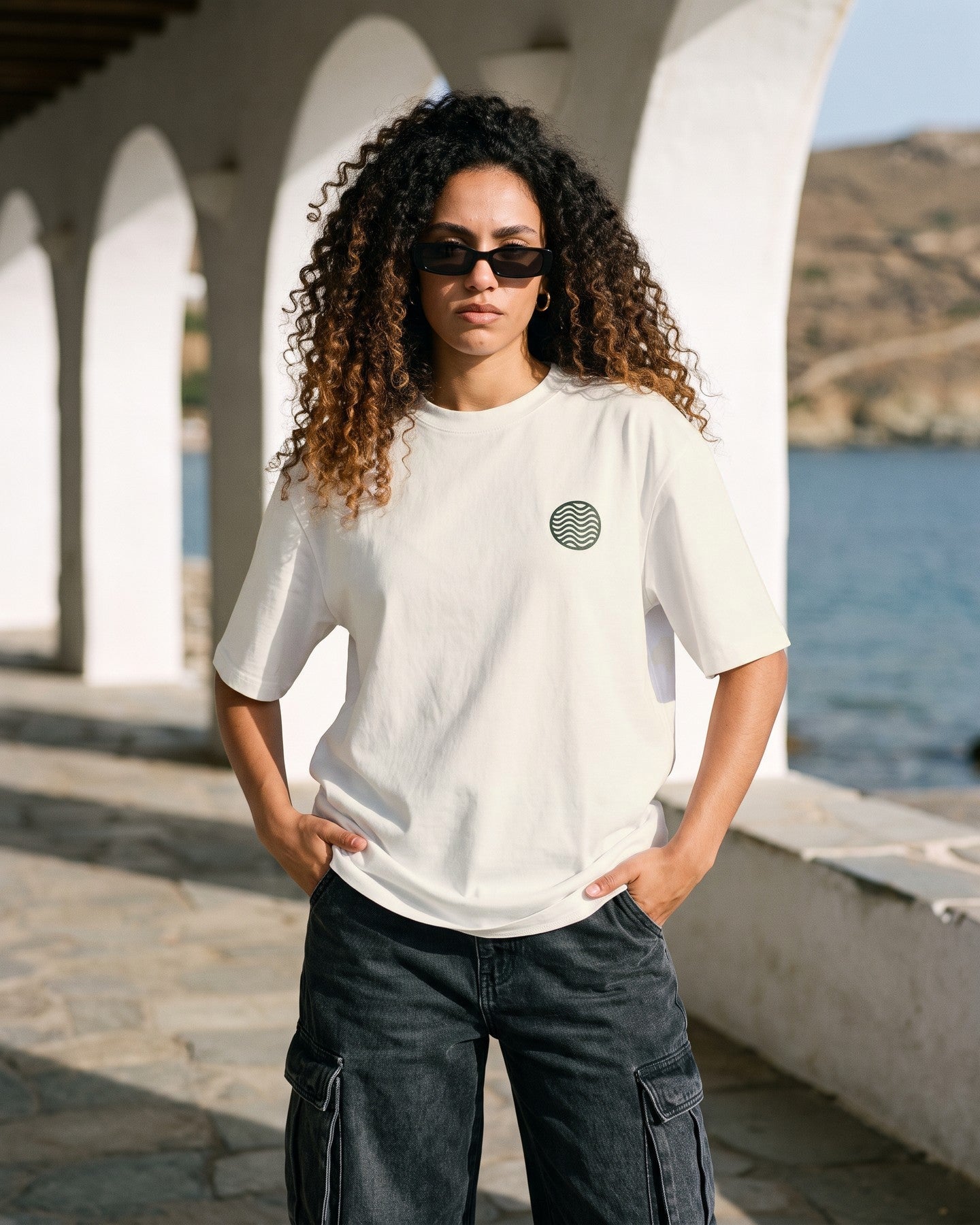 Mulher usando a camiseta oversized MALTA® neymar or me off-white numa galeria de arcos caiados