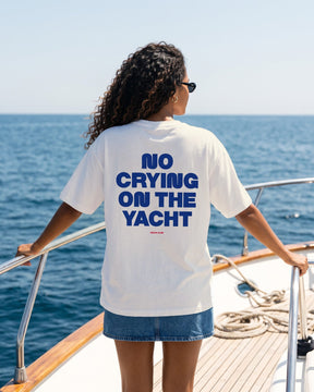 Mulher de costas usando a camiseta oversized MALTA® no crying on the yacht off-white no convés de um iate