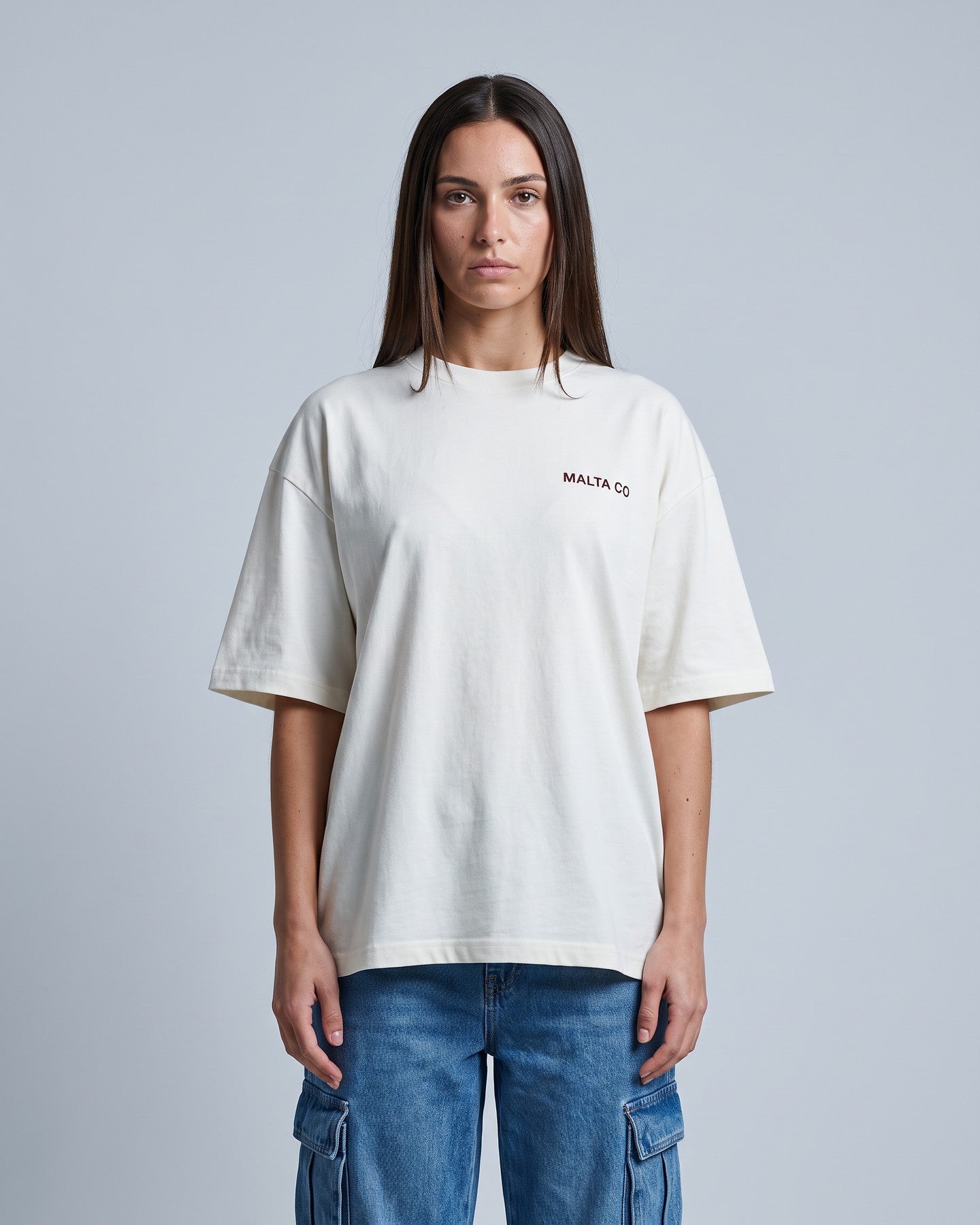 Camiseta oversized feminina MALTA® nobody knows off-white vestida de frente, no estúdio