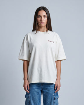 Camiseta oversized feminina MALTA® nobody knows off-white vestida de frente, no estúdio