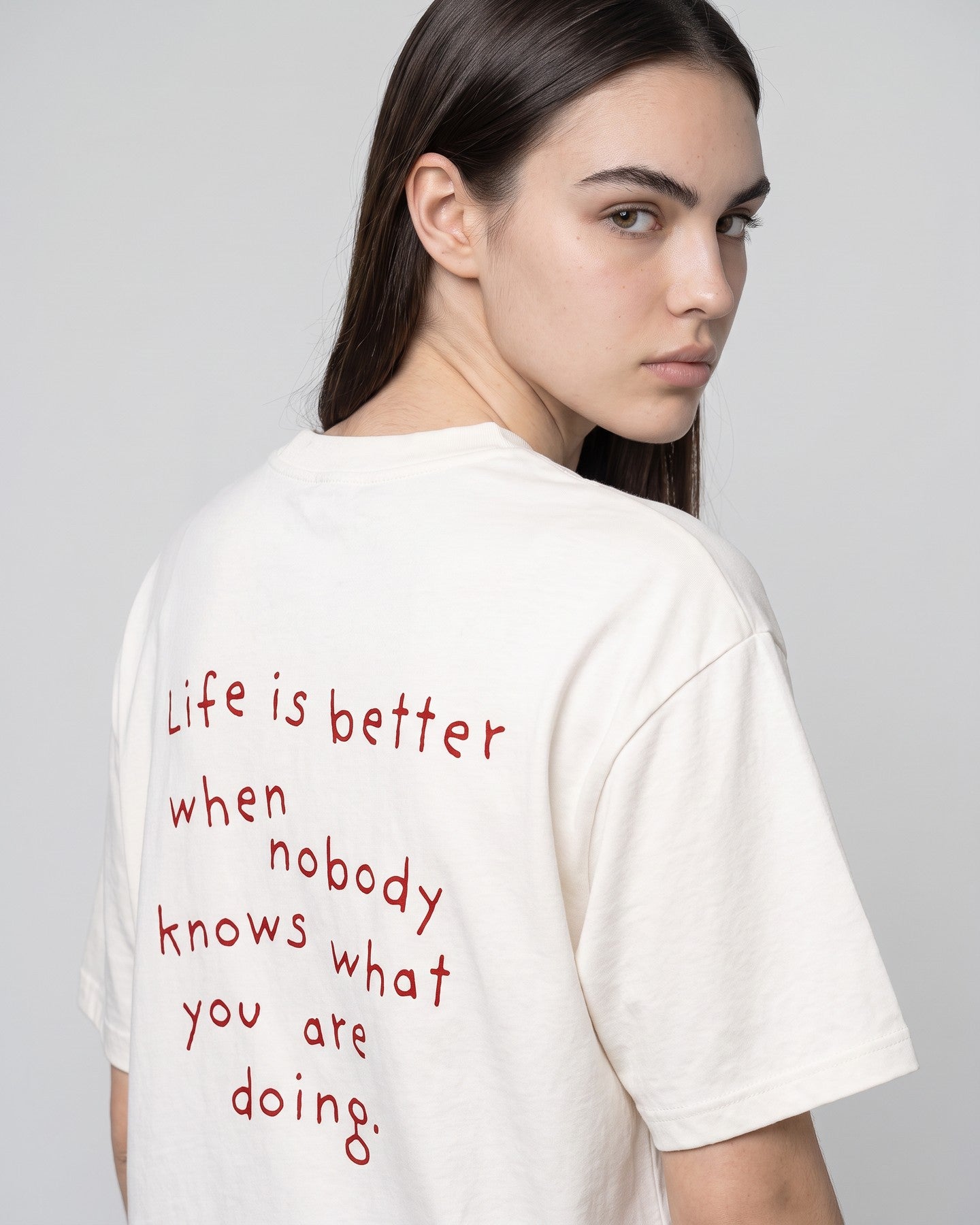 Detalhe da camiseta oversized MALTA® nobody knows off-white no corpo feminino