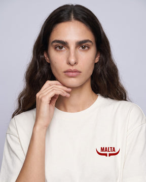 Detalhe da camiseta oversized MALTA® red flags off-white no corpo feminino
