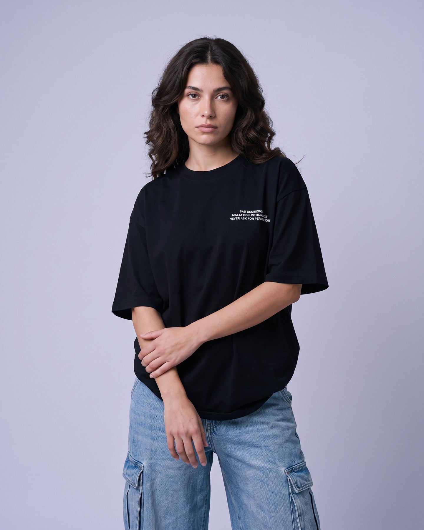 Camiseta oversized feminina MALTA® bad decisions preta vestida de frente, no estúdio