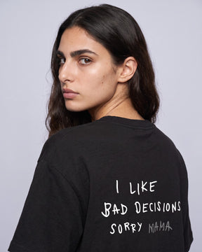 Detalhe da camiseta oversized MALTA® bad decisions preta no corpo feminino