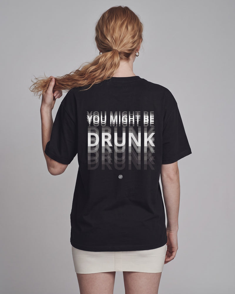 Camiseta oversized feminina MALTA® you might be drunk preta vista de costas no estúdio, com a frase “you might be drunk”