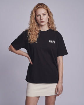 Camiseta oversized feminina MALTA® you might be drunk preta vestida de frente, no estúdio